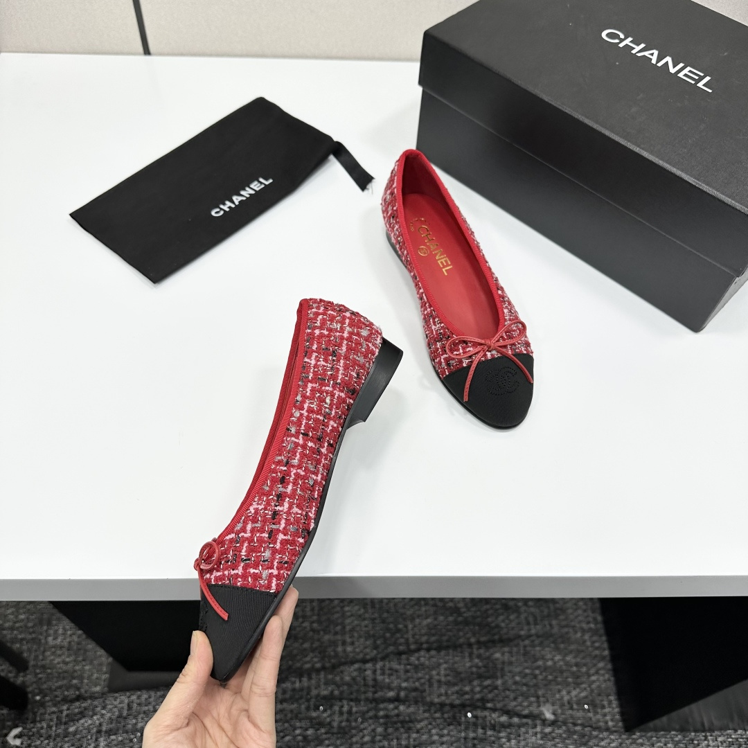 A pair of luxury Chanel ballet flats made of red tweed with black cap toes and CC logo on a black designer box - Hình 2