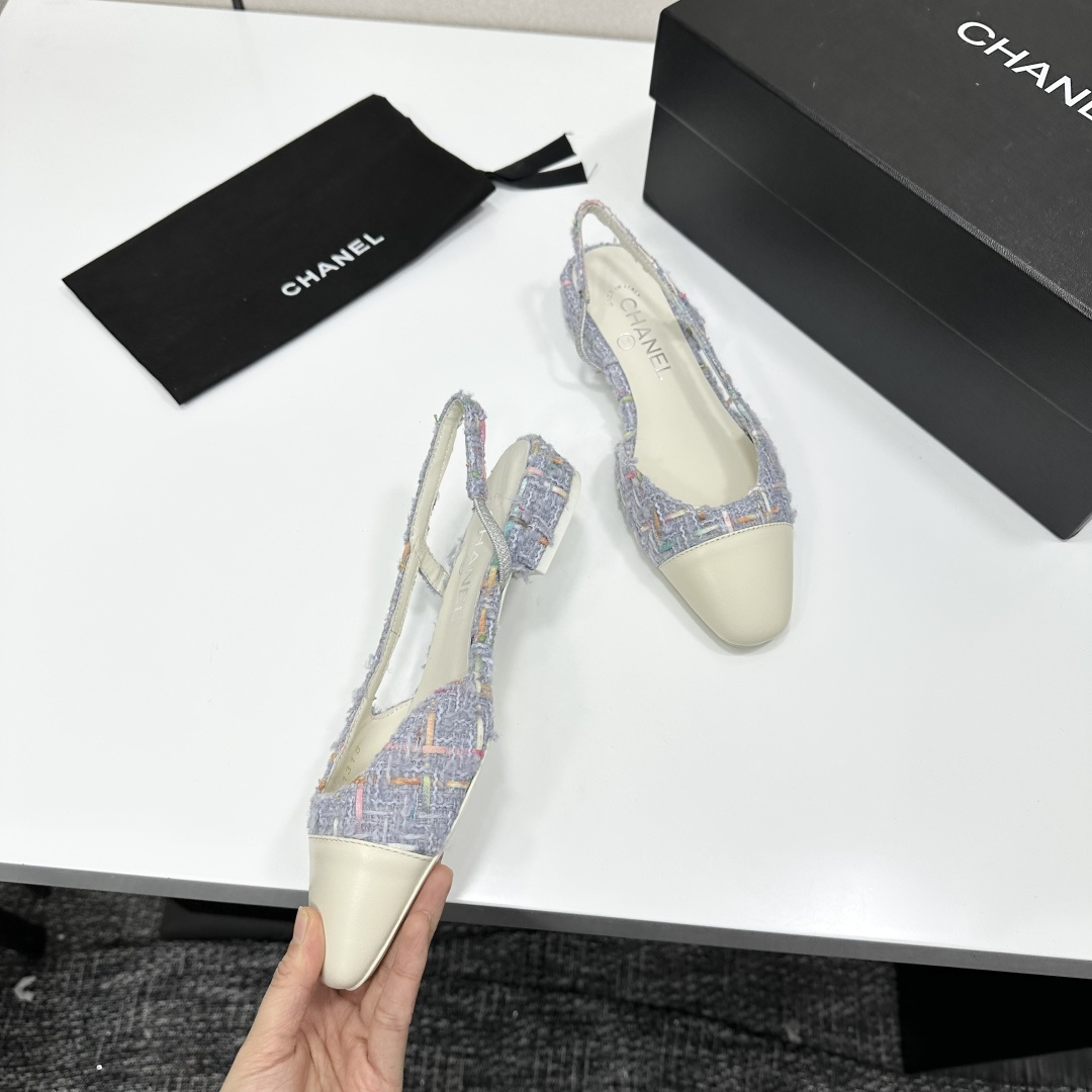 A pair of Chanel blue multi-color tweed slingback flats with cream leather cap toes resting on a black designer box - Hình 10