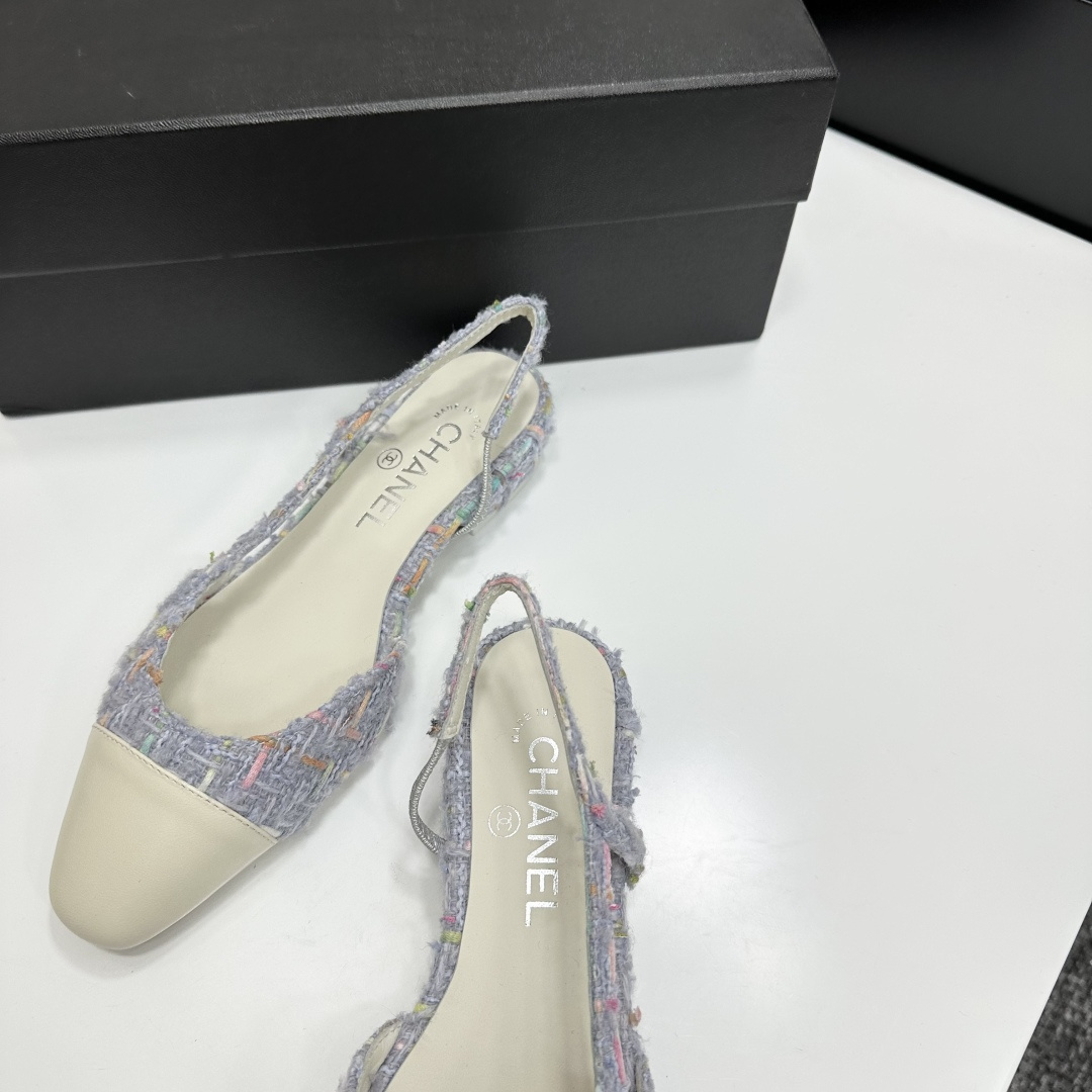 A pair of Chanel blue multi-color tweed slingback flats with cream leather cap toes resting on a black designer box - Hình 8