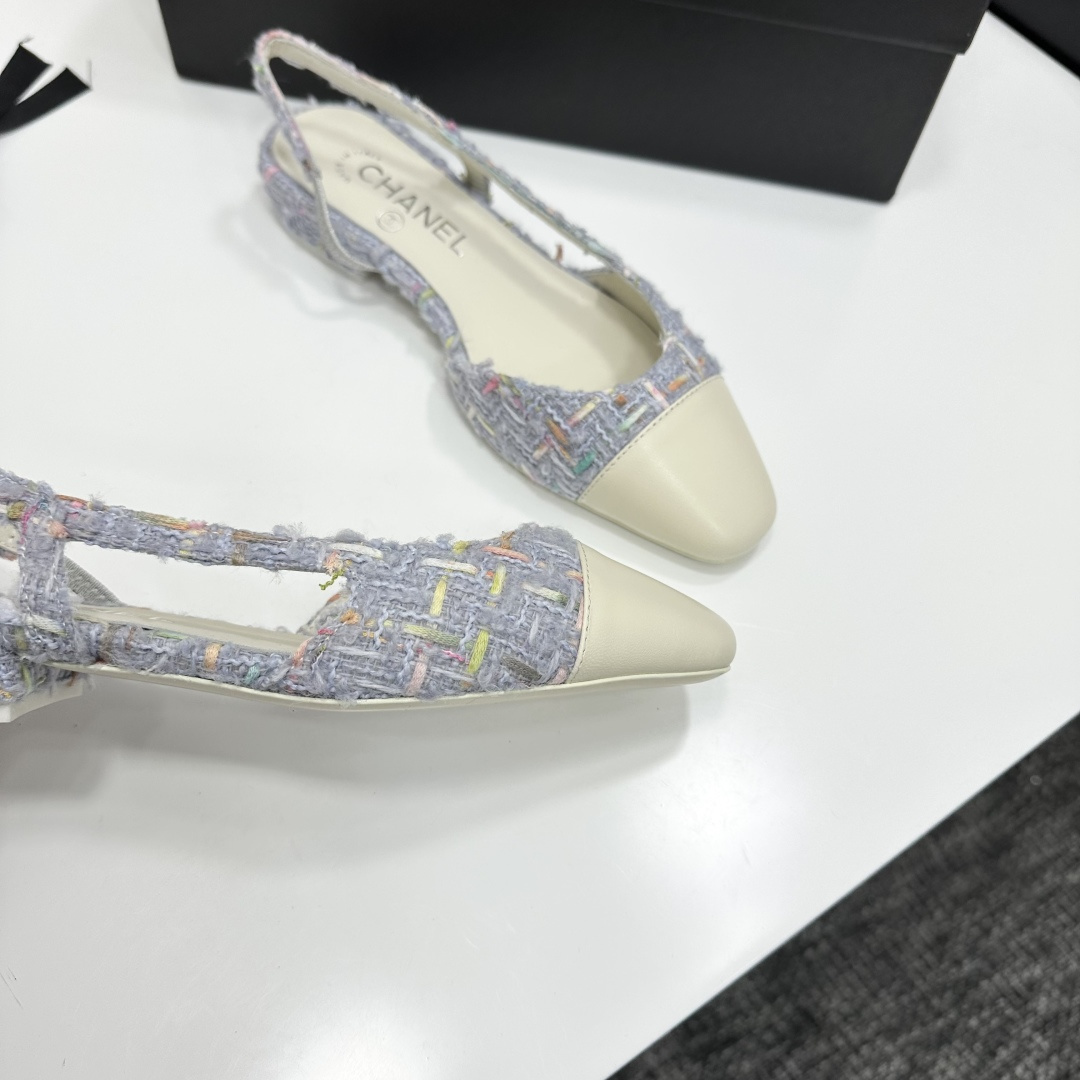 A pair of Chanel blue multi-color tweed slingback flats with cream leather cap toes resting on a black designer box - Hình 2