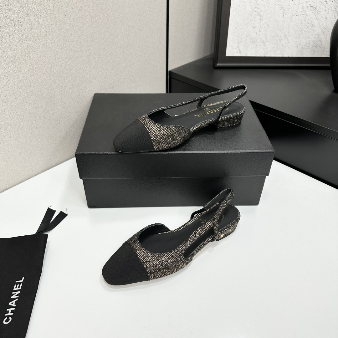 A pair of Chanel gold and black tweed slingback flats with black cap toes displayed on a black designer box. - Hình 3