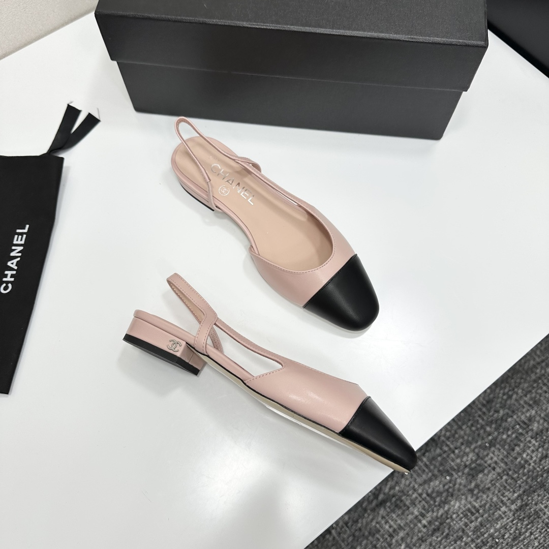A pair of luxury Chanel pink and black two-tone slingback flats resting on a black designer shoe box. - Hình 10