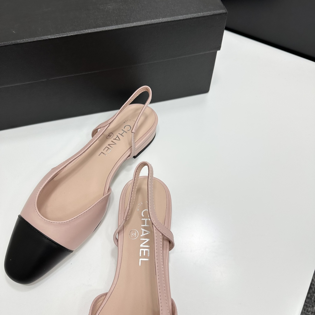 A pair of luxury Chanel pink and black two-tone slingback flats resting on a black designer shoe box. - Hình 8