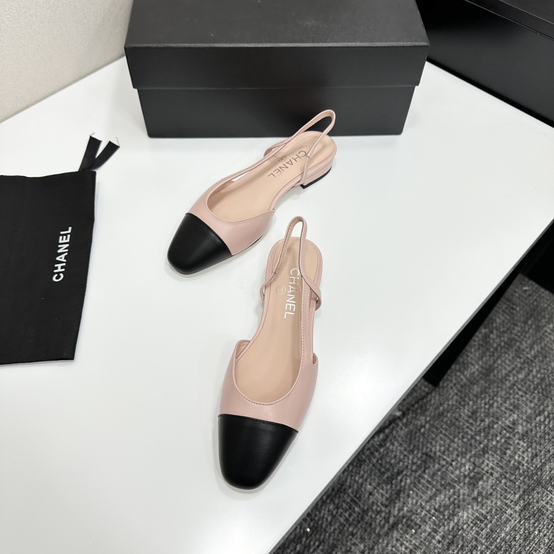 A pair of luxury Chanel pink and black two-tone slingback flats resting on a black designer shoe box. - Hình 6