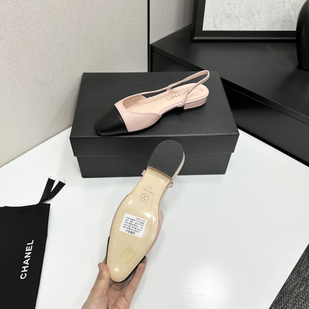 A pair of luxury Chanel pink and black two-tone slingback flats resting on a black designer shoe box. - Hình 5