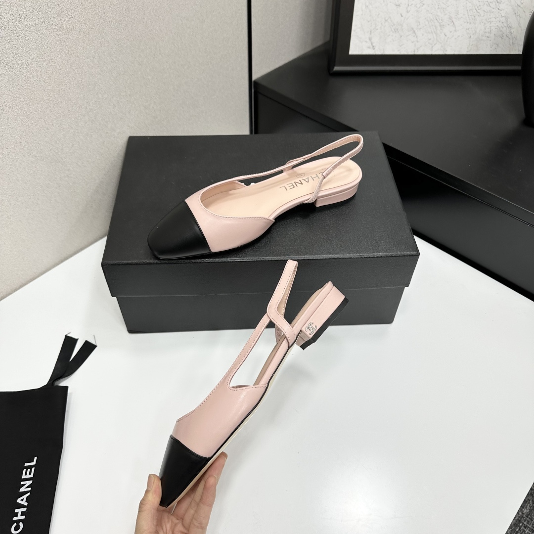 A pair of luxury Chanel pink and black two-tone slingback flats resting on a black designer shoe box. - Hình 4