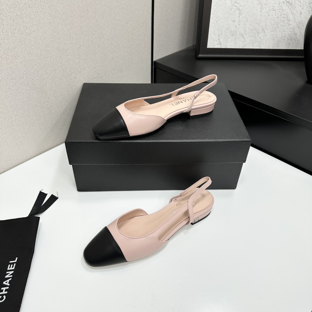 A pair of luxury Chanel pink and black two-tone slingback flats resting on a black designer shoe box. - Hình 3
