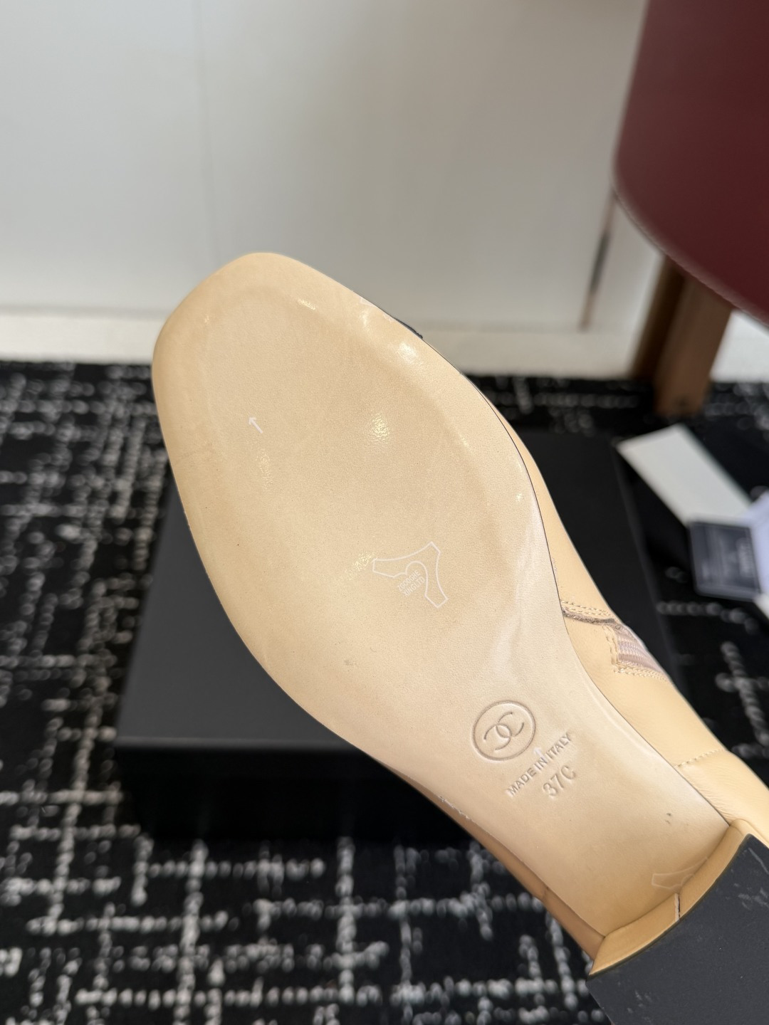 A pair of Chanel two-tone beige leather ankle boots with black fabric cap-toes and gold CC logo on the block heels, presented on a black Chanel box. - Hình 9