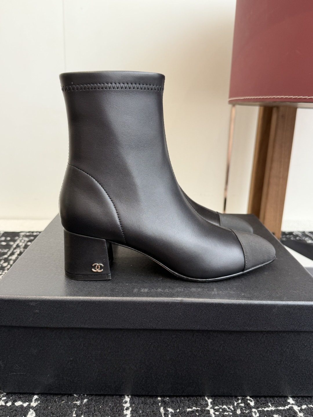 Pair of Chanel black leather ankle boots with cap toe and gold CC logo on block heel. - Hình 2