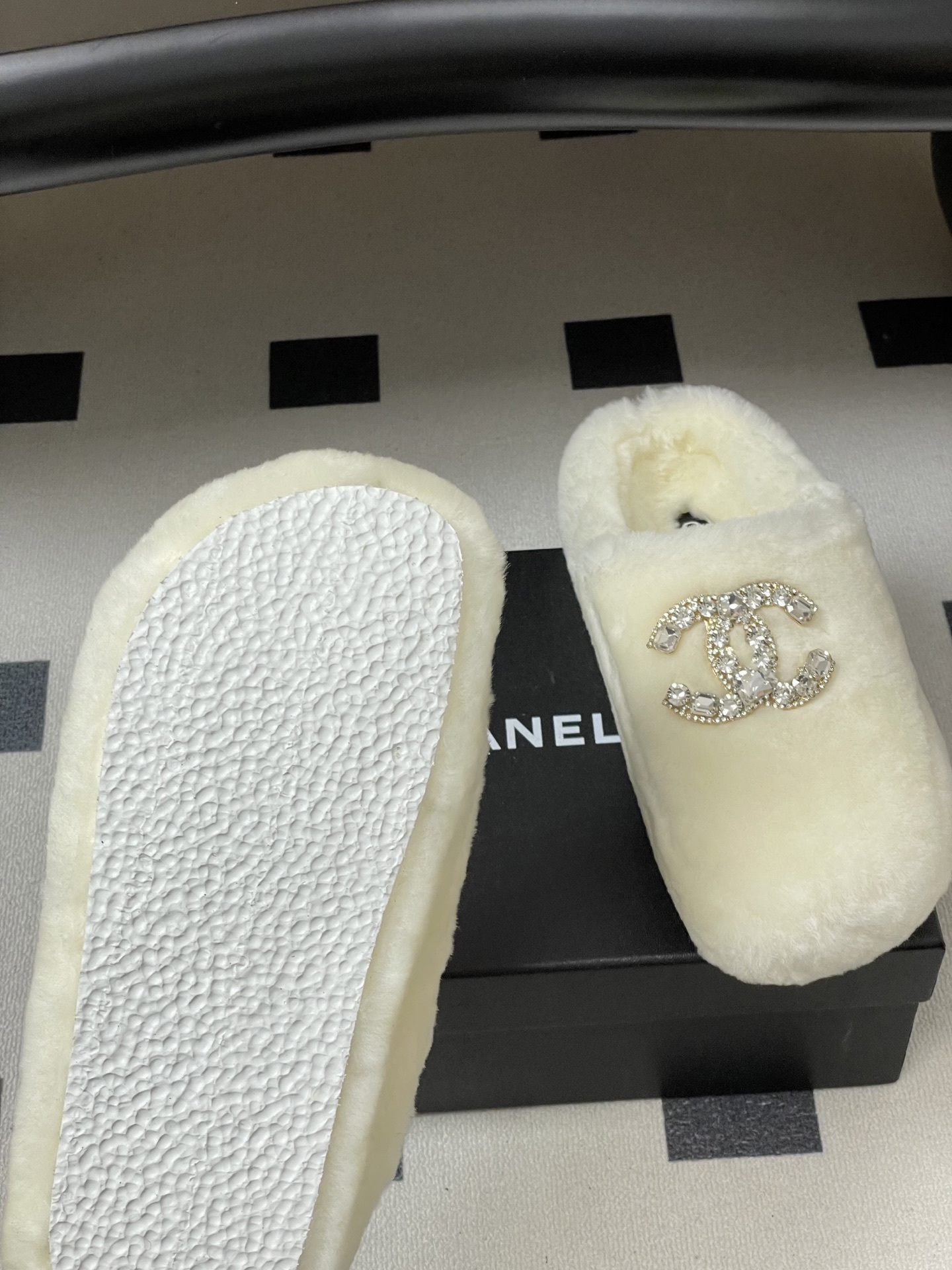 A pair of plush white faux fur slippers featuring a large sparkling crystal encrusted double-C logo on the top. - Hình 8