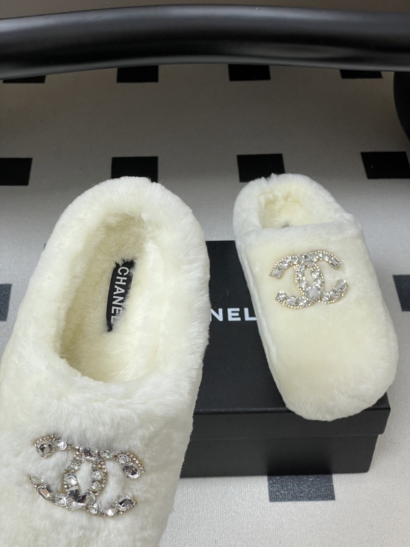 A pair of plush white faux fur slippers featuring a large sparkling crystal encrusted double-C logo on the top. - Hình 7
