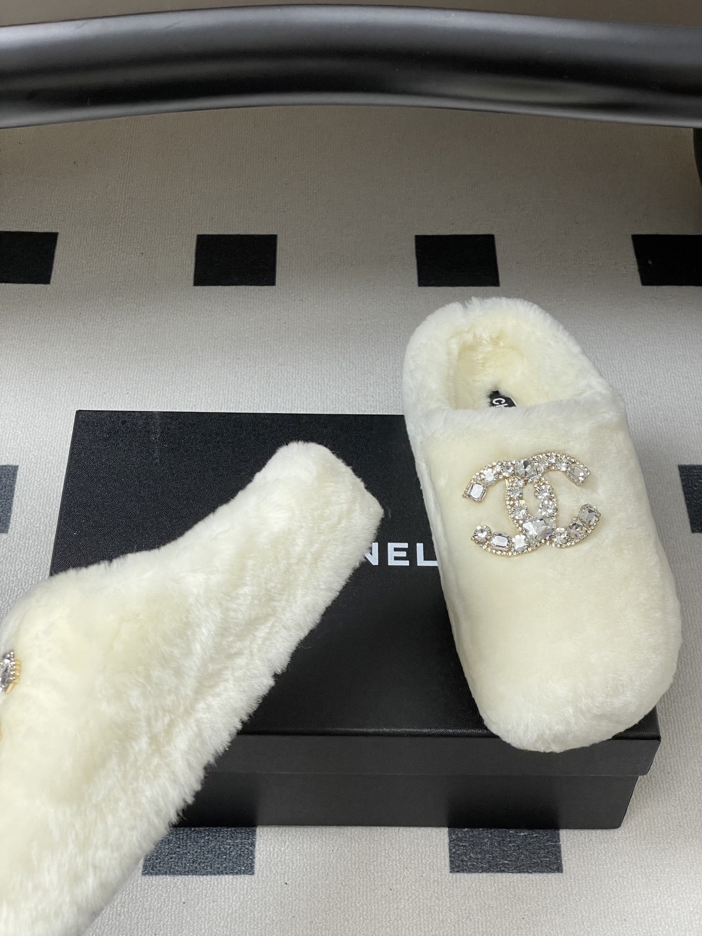 A pair of plush white faux fur slippers featuring a large sparkling crystal encrusted double-C logo on the top. - Hình 6