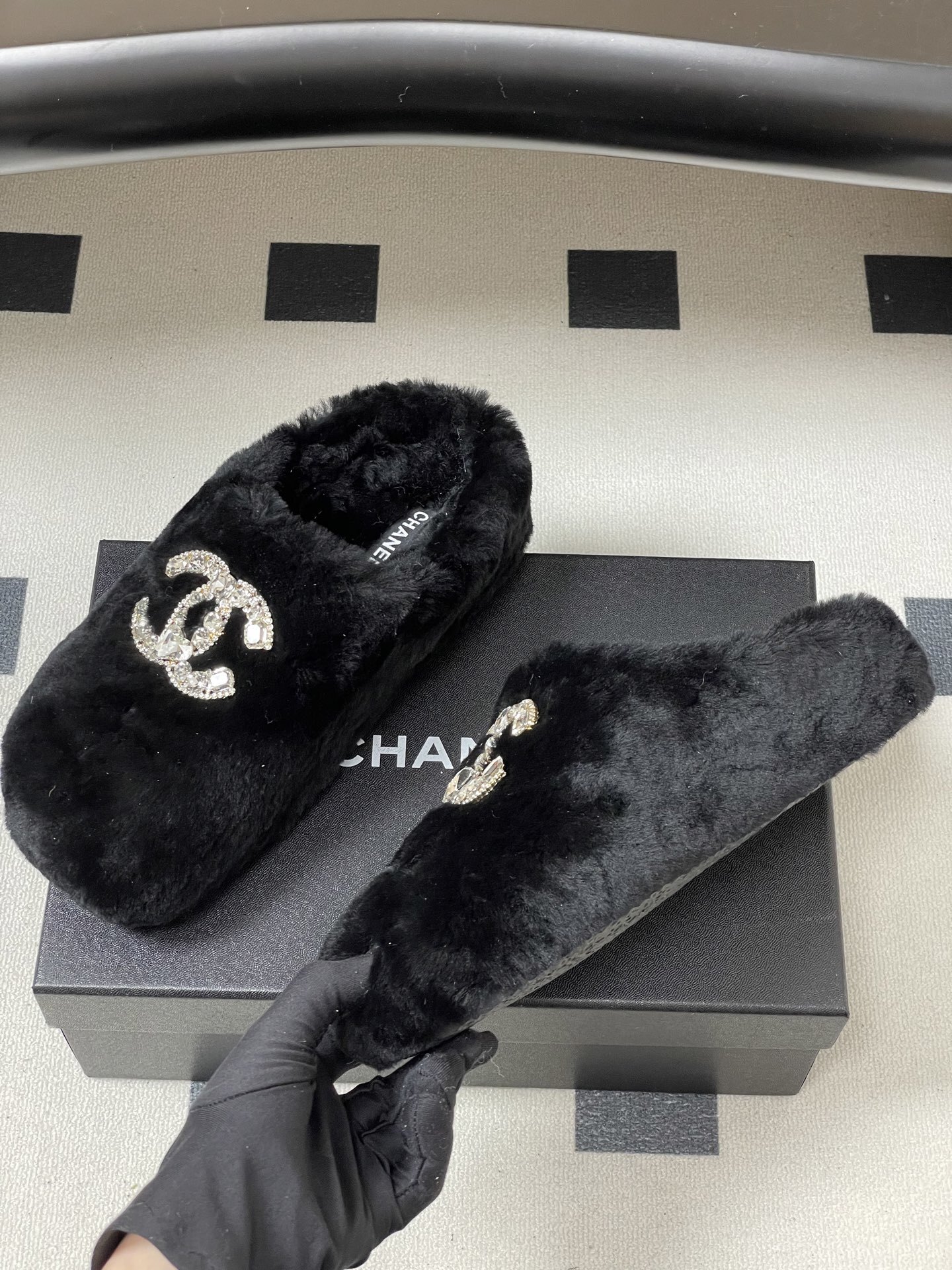 Elegant black fluffy slippers featuring a prominent crystal-studded double-C logo design on a black surface. - Hình 4