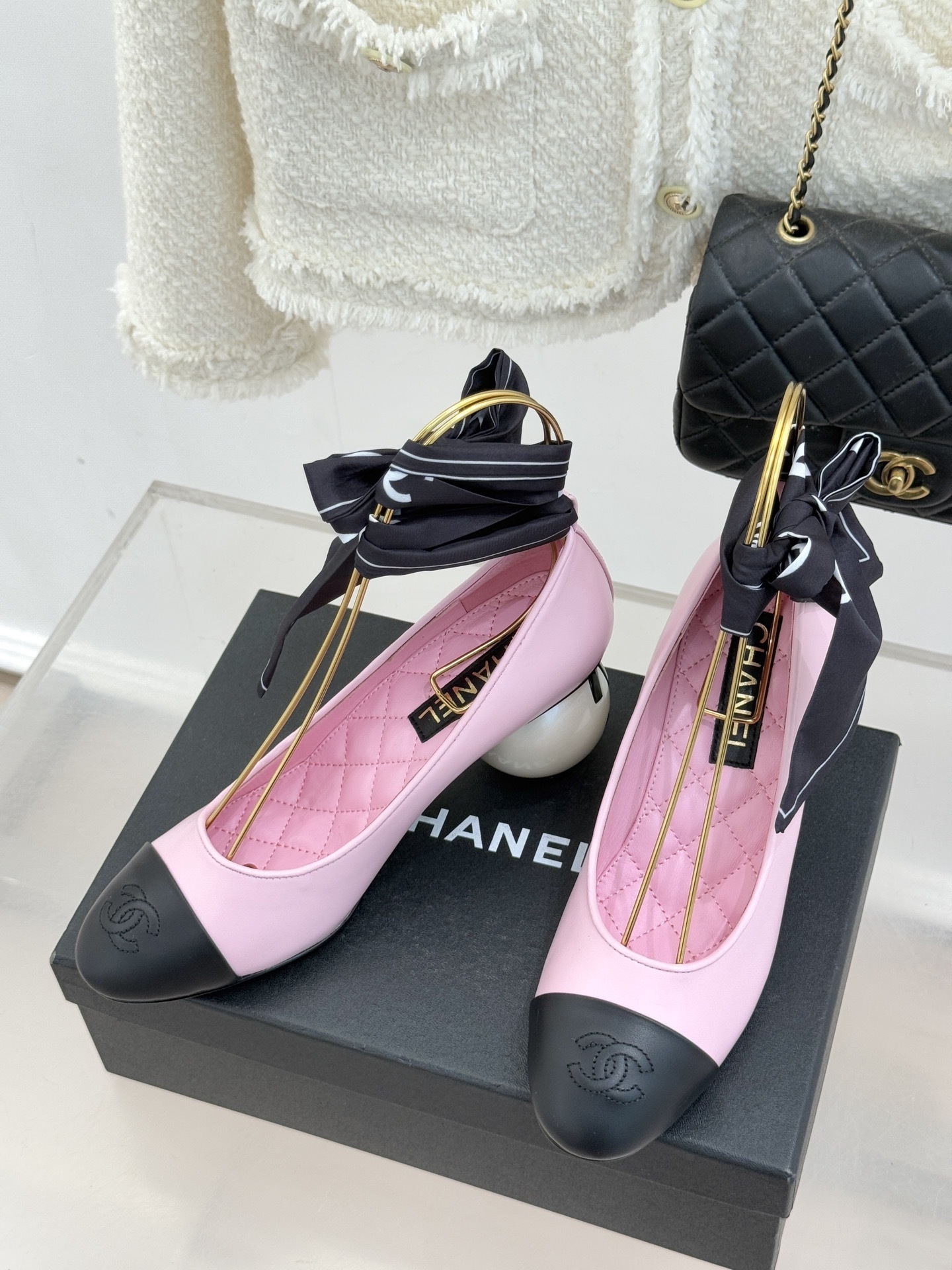 Luxury Chanel pink leather pumps with black cap toe, unique white pearl heel, and black silk scarf bow detail. - Hình 2