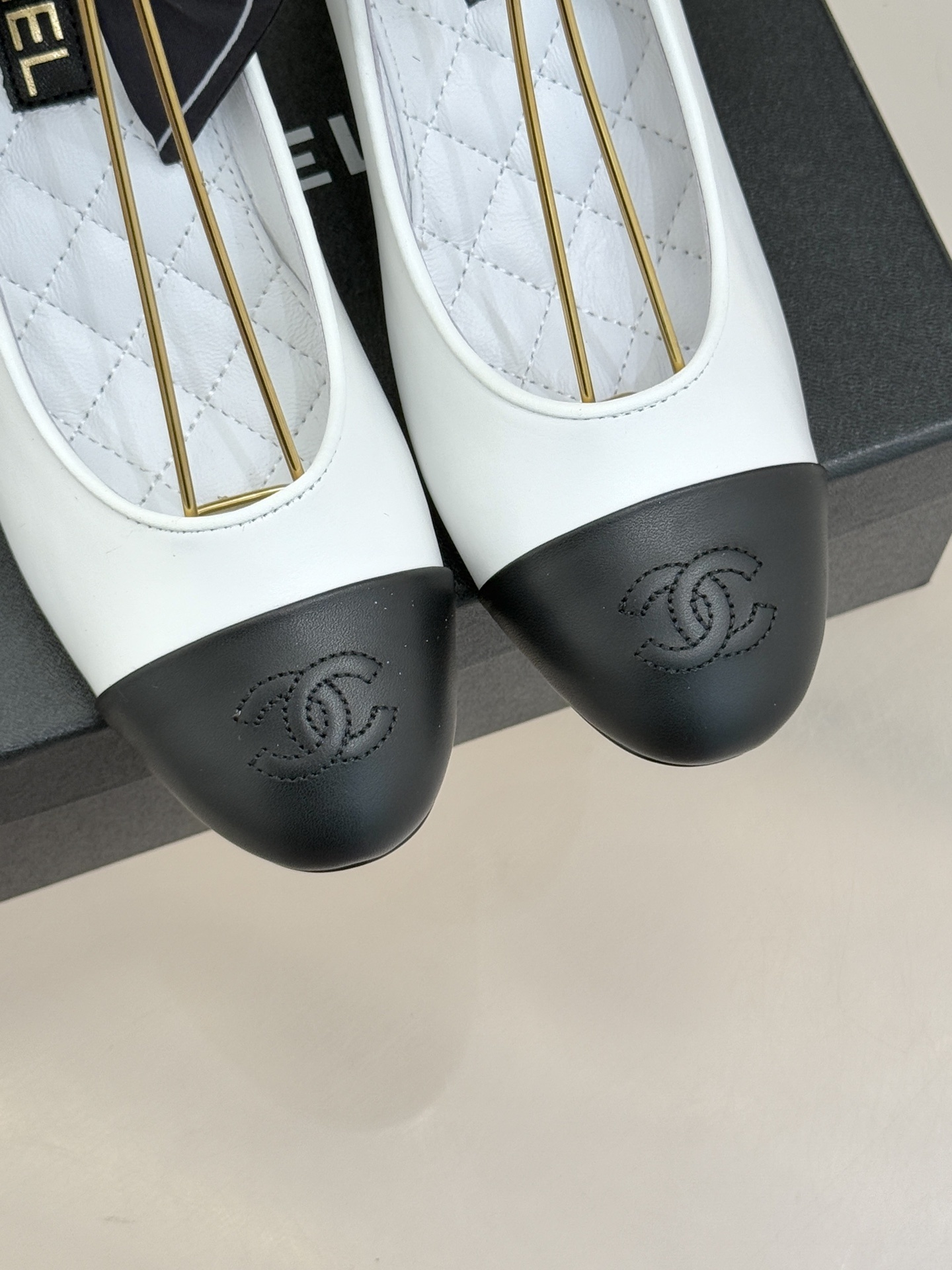 Elegant white and black two-tone pumps featuring a unique pearl sphere heel and a black silk scarf ankle tie, resting on a black designer box. - Hình 7