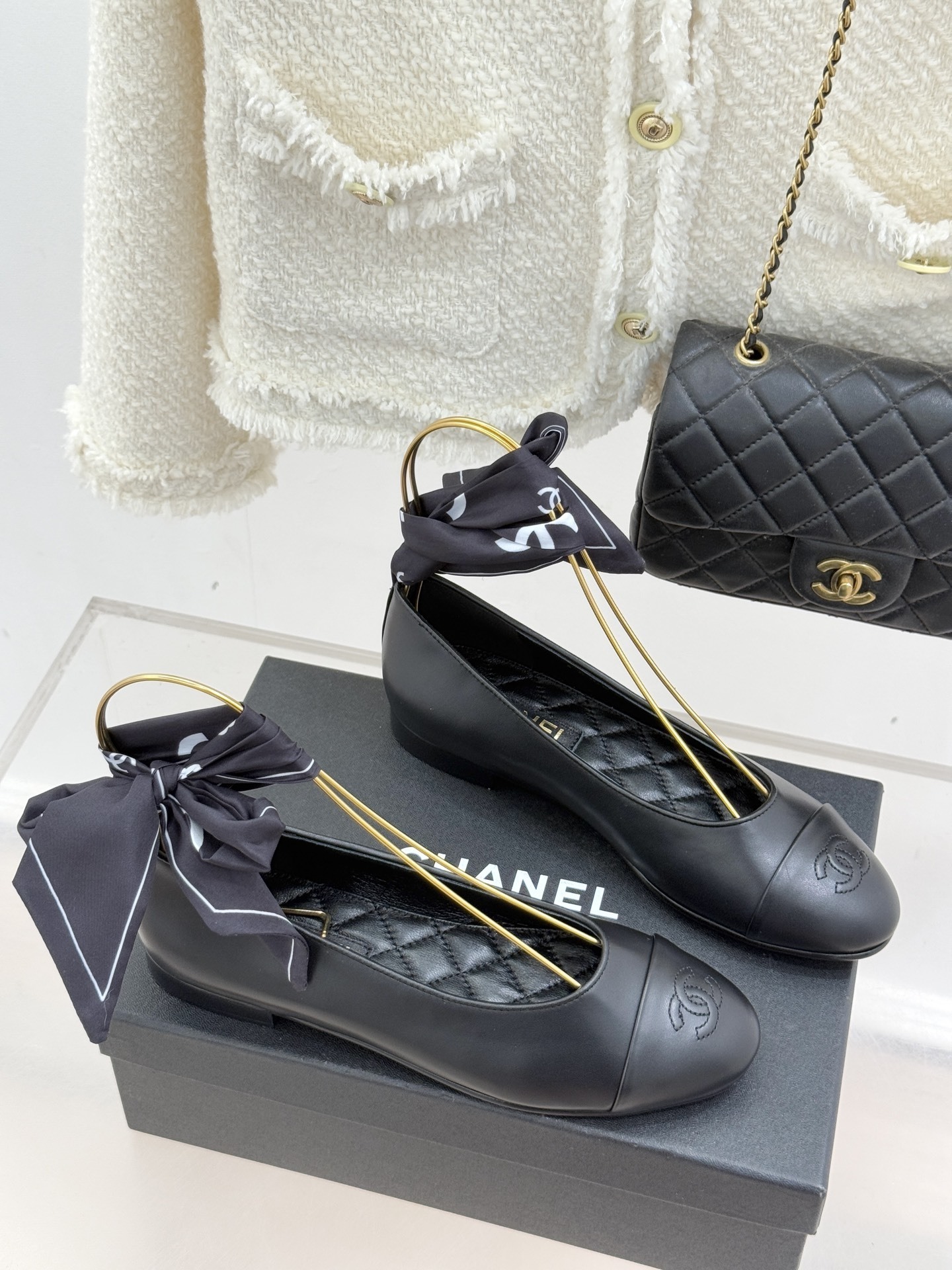 Elegant black leather ballet flats with CC logo on toe and black silk scarf ankle ribbons displayed on a black box - Hình 3