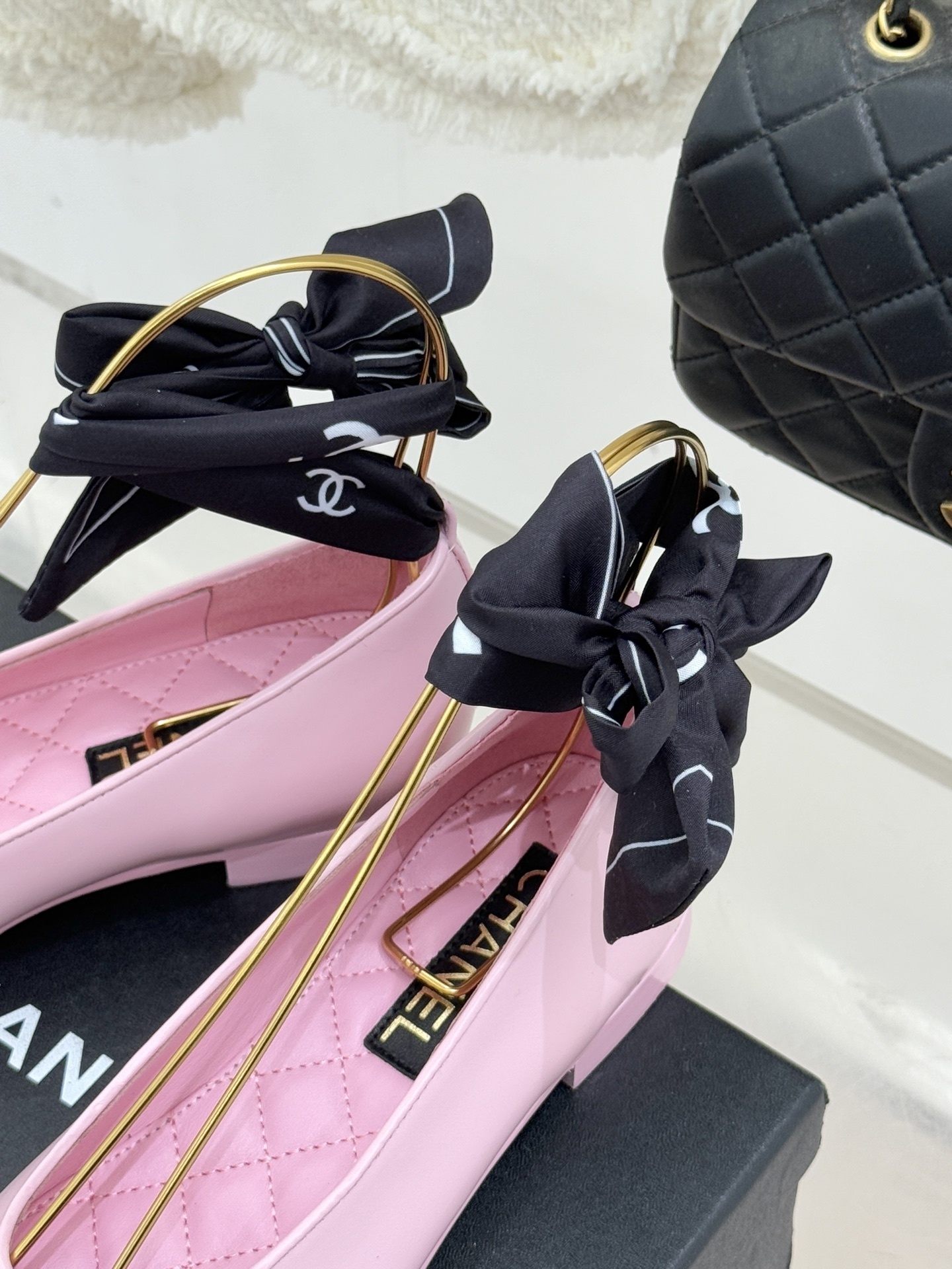 Luxury Chanel pink leather ballet flats with black toe caps and embossed logo on a branded box. - Hình 8