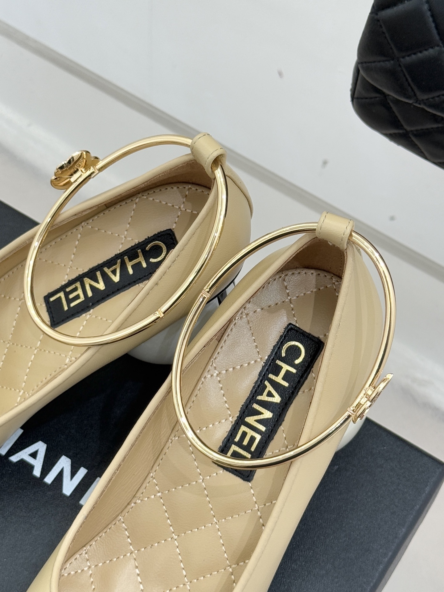 Luxury beige and black two-tone pumps with a white pearl heel and gold-tone ankle ring featuring a camellia charm. - Hình 8