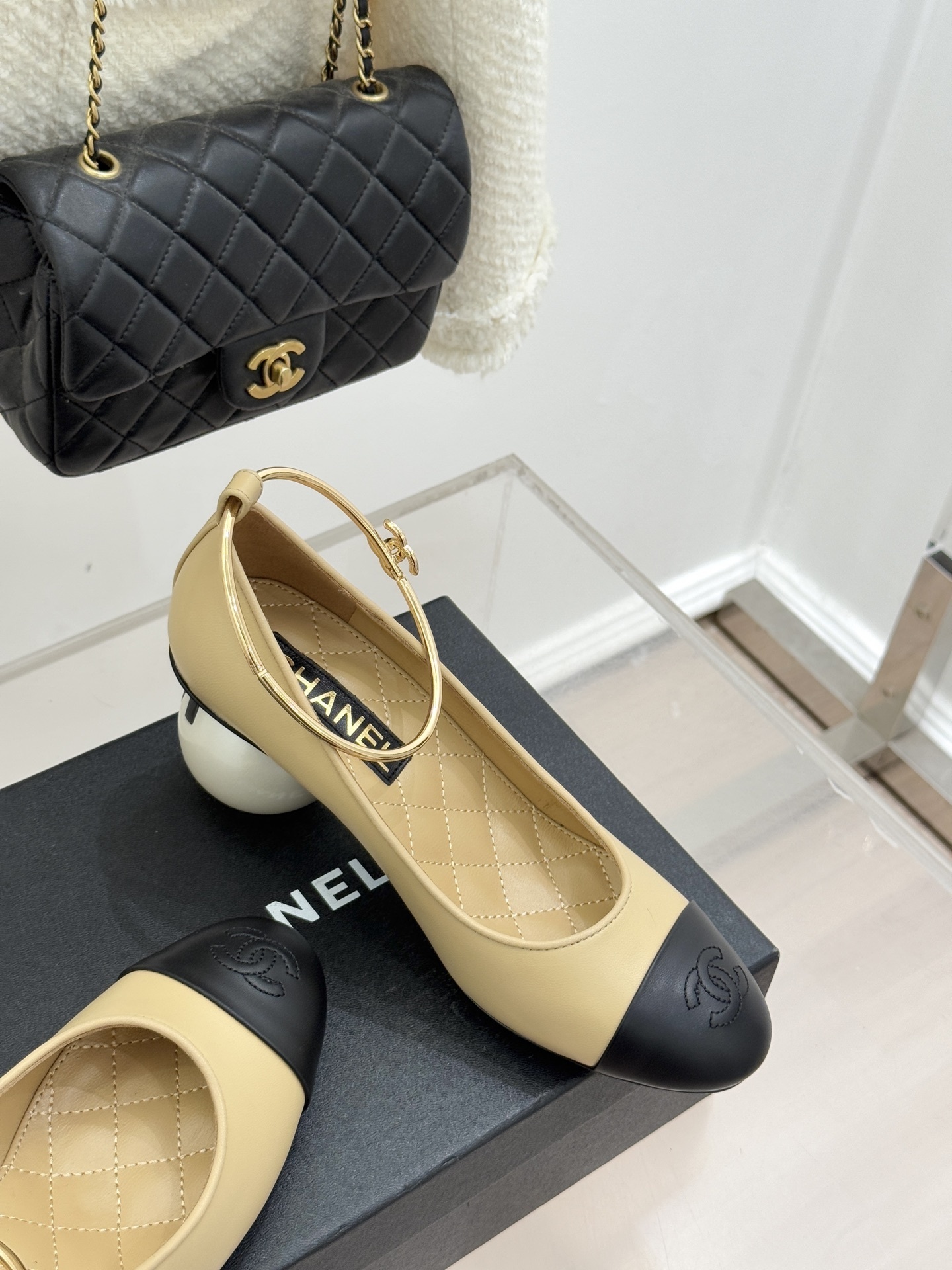 Luxury beige and black two-tone pumps with a white pearl heel and gold-tone ankle ring featuring a camellia charm. - Hình 5