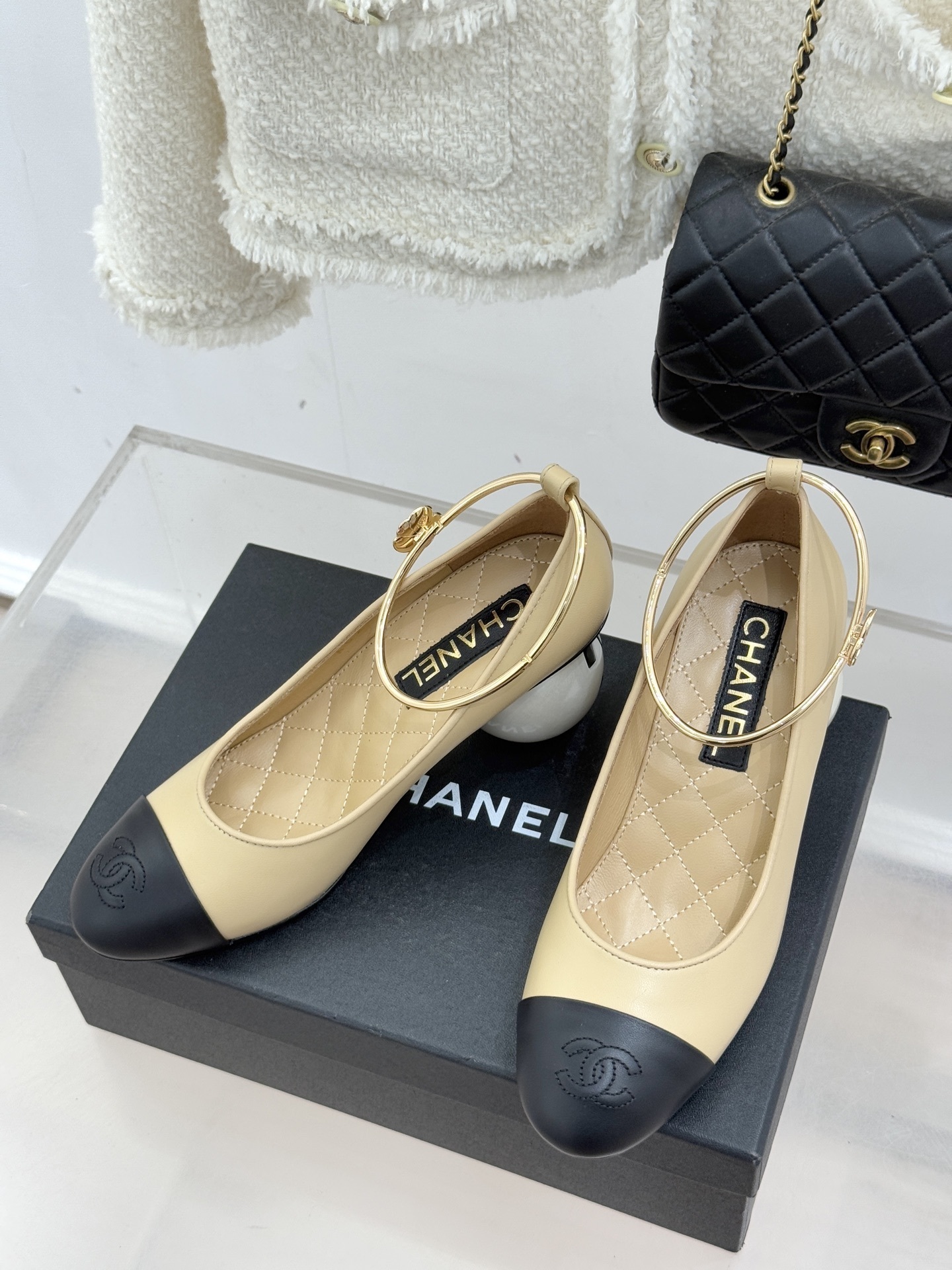 Luxury beige and black two-tone pumps with a white pearl heel and gold-tone ankle ring featuring a camellia charm. - Hình 2