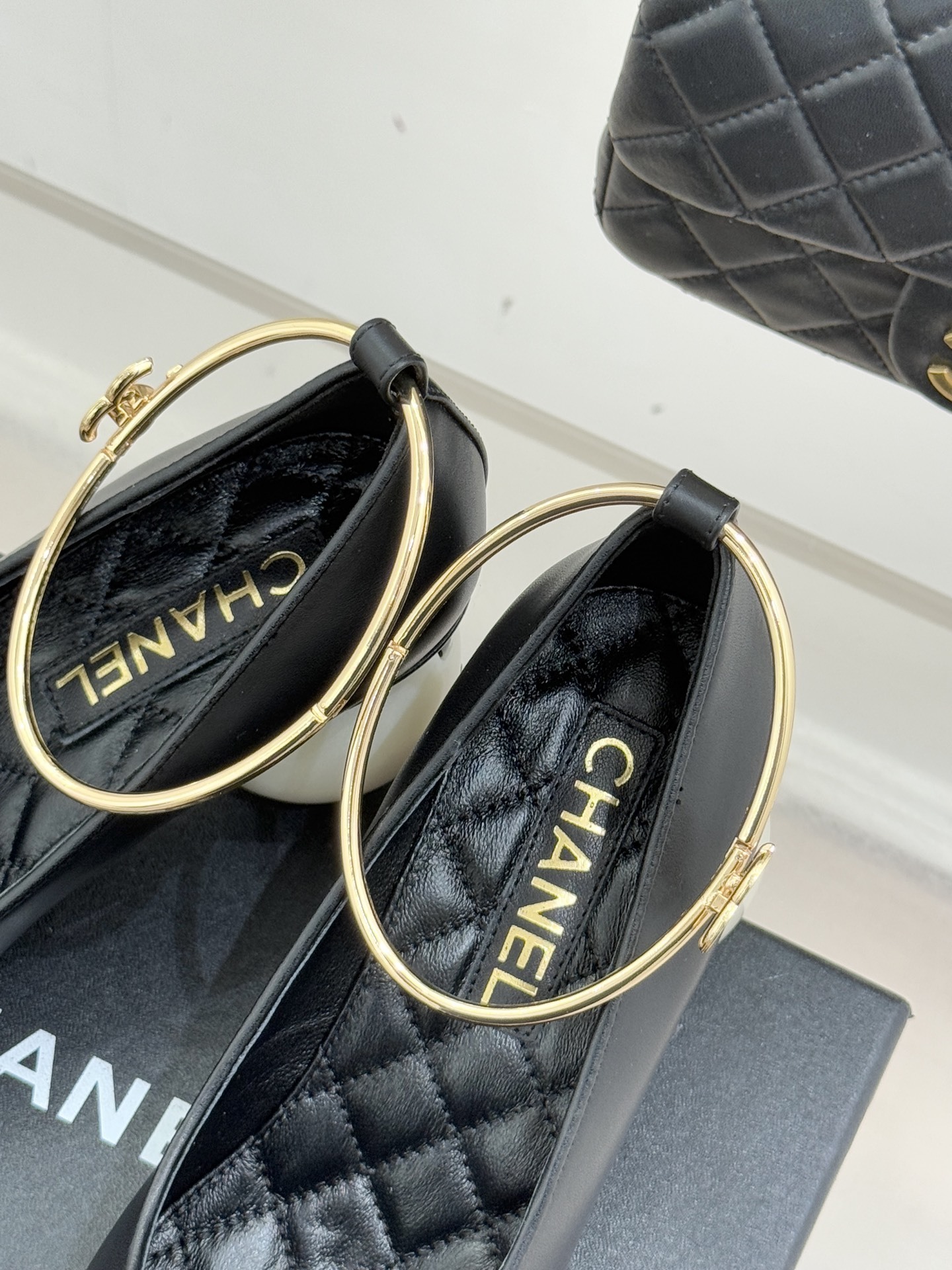 A pair of Chanel black leather pumps featuring unique white spherical pearl heels and gold-tone ankle straps with the CC logo. - Hình 8