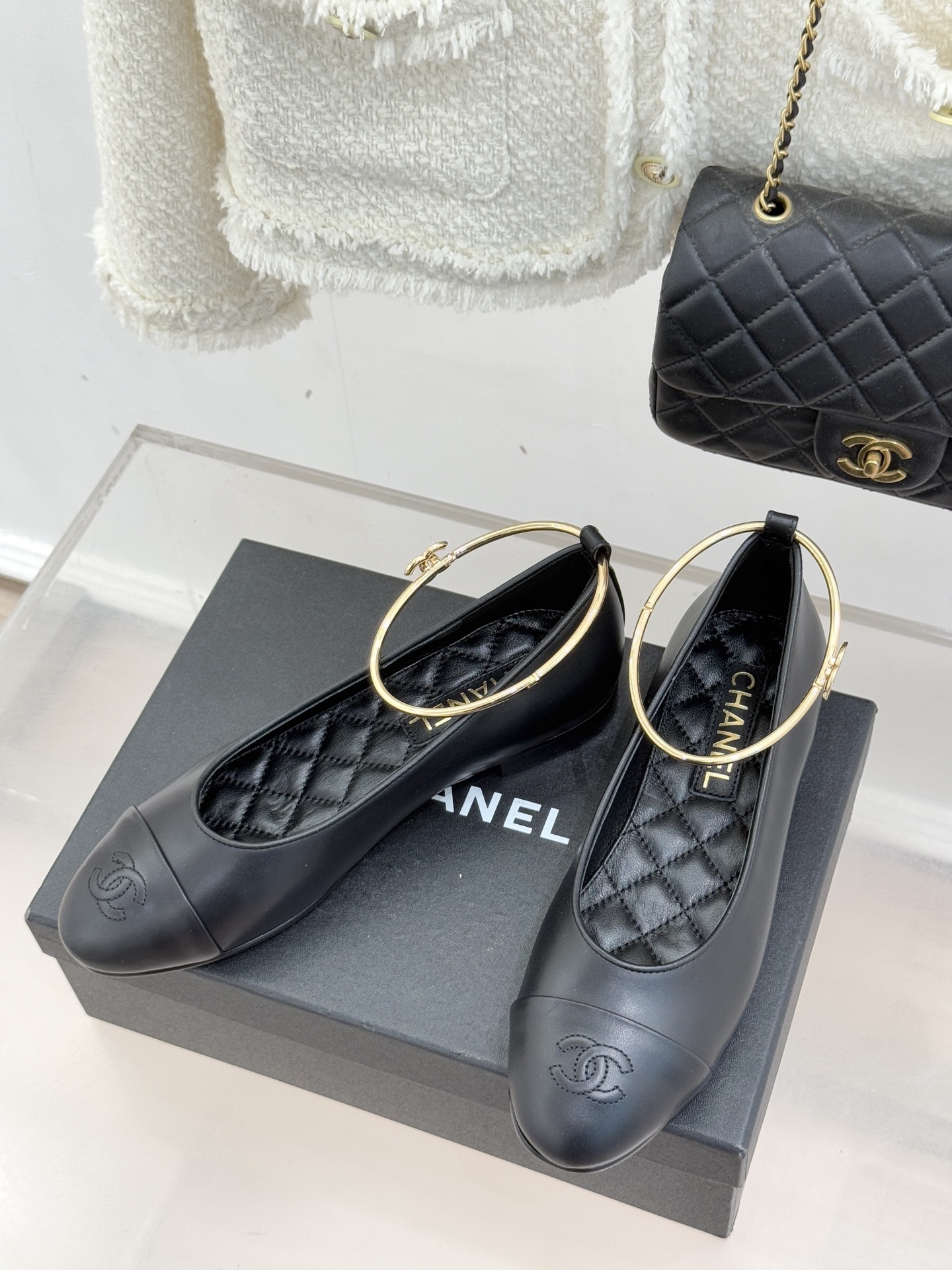 Pair of black Chanel lambskin ballet flats with gold-tone rigid ankle rings and embossed CC logos on the toe caps. - Hình 2