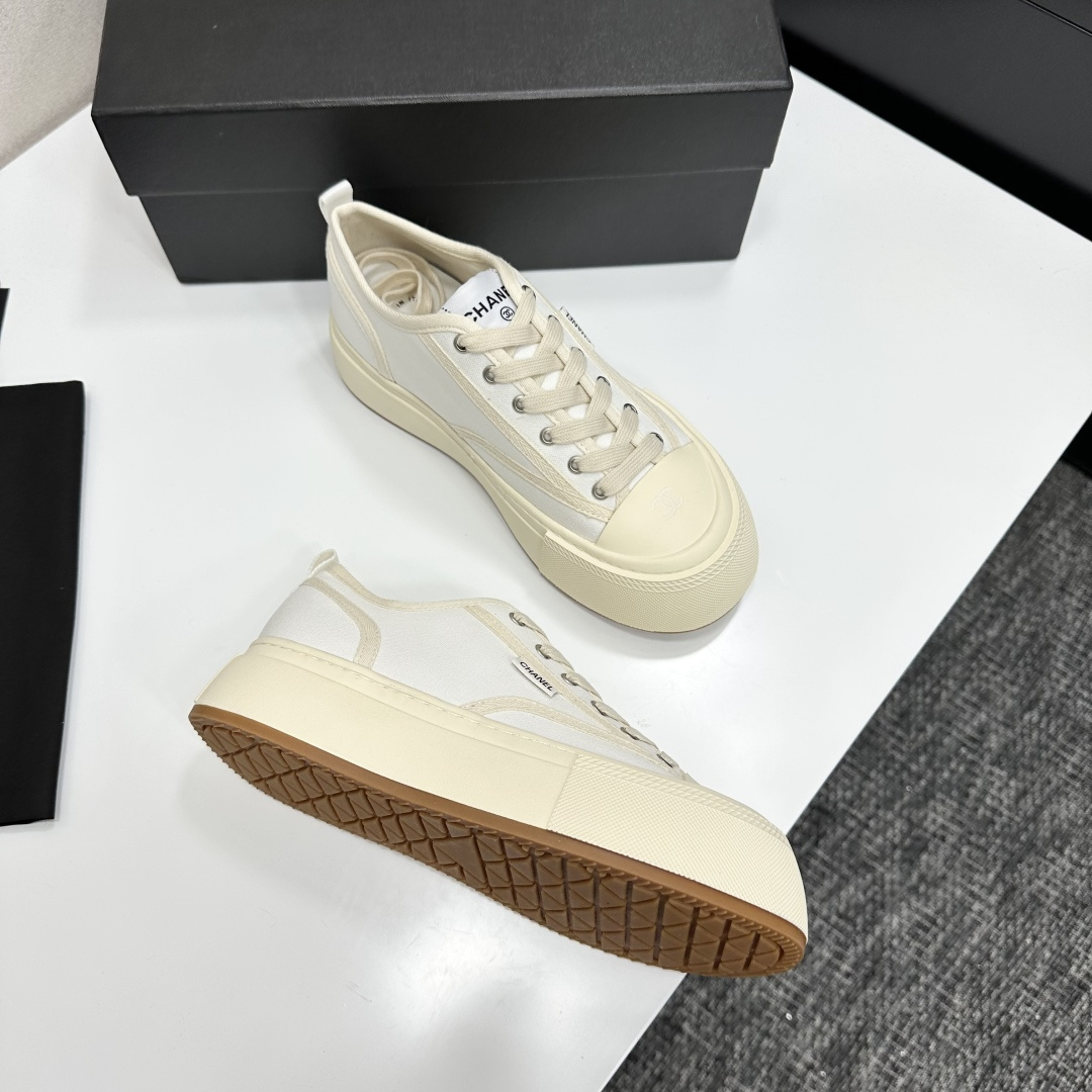 Side view of Chanel white canvas platform sneakers with chunky cream soles on a black box - Hình 8