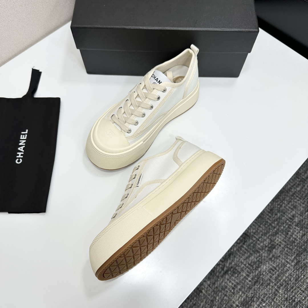 Side view of Chanel white canvas platform sneakers with chunky cream soles on a black box - Hình 6