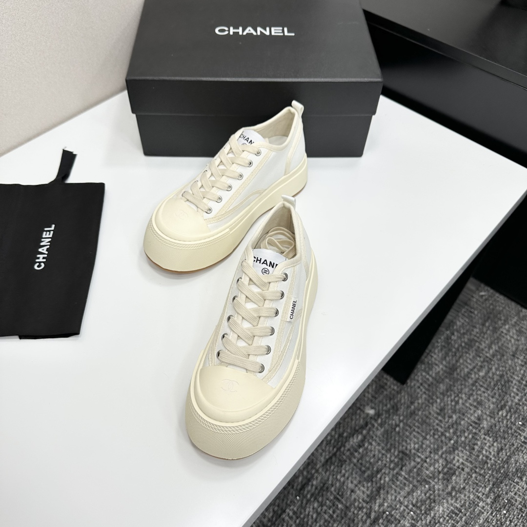 Side view of Chanel white canvas platform sneakers with chunky cream soles on a black box - Hình 5