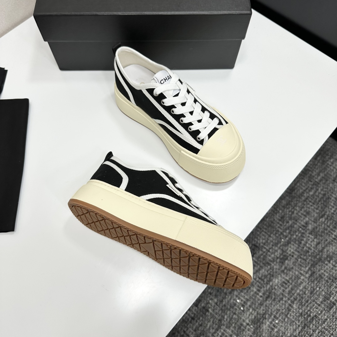 Chanel black canvas platform sneakers with white trim and thick cream soles on a black luxury box - Hình 10