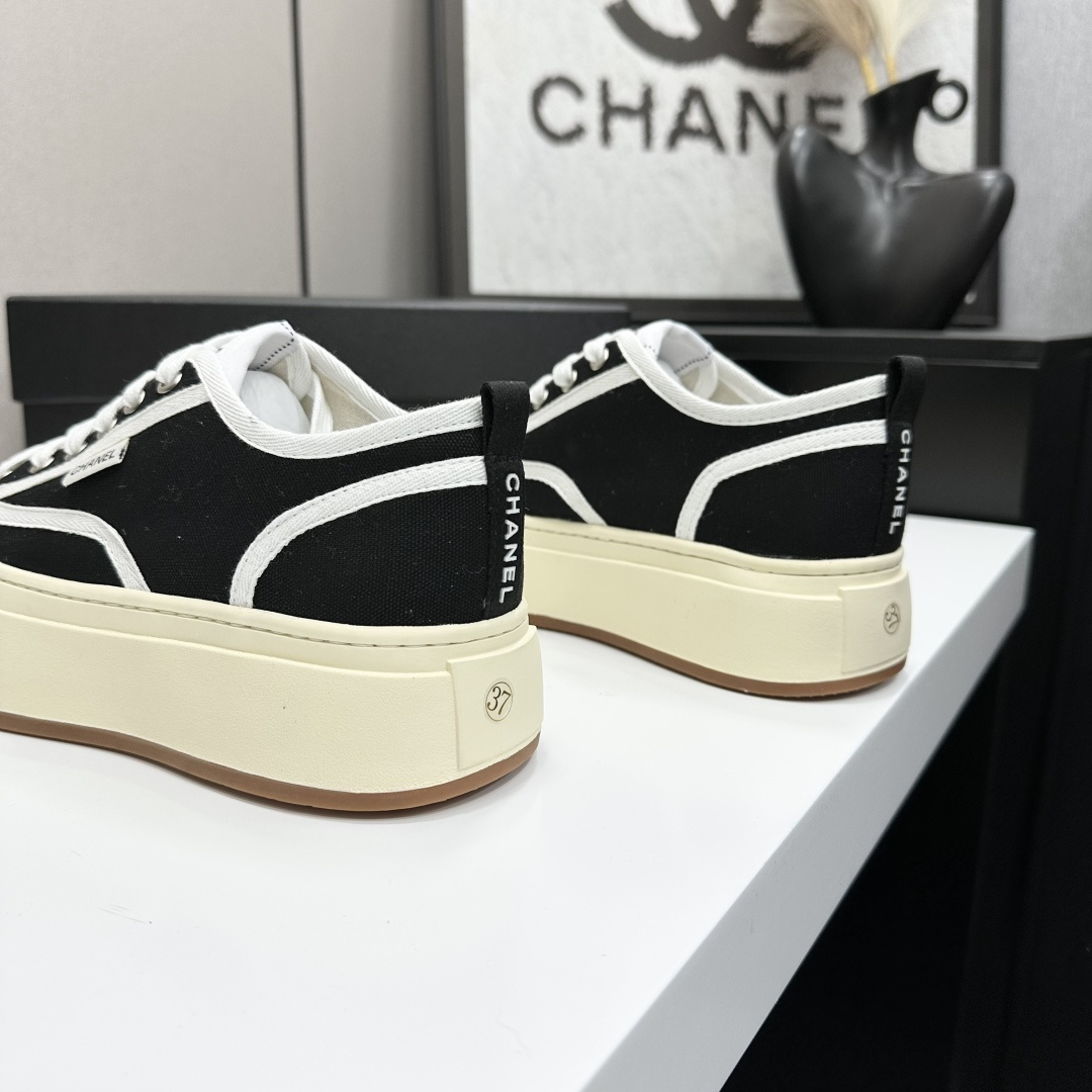 Chanel black canvas platform sneakers with white trim and thick cream soles on a black luxury box - Hình 9