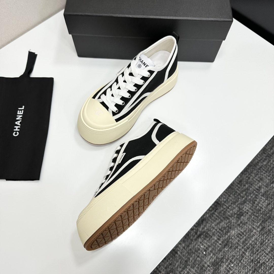Chanel black canvas platform sneakers with white trim and thick cream soles on a black luxury box - Hình 7