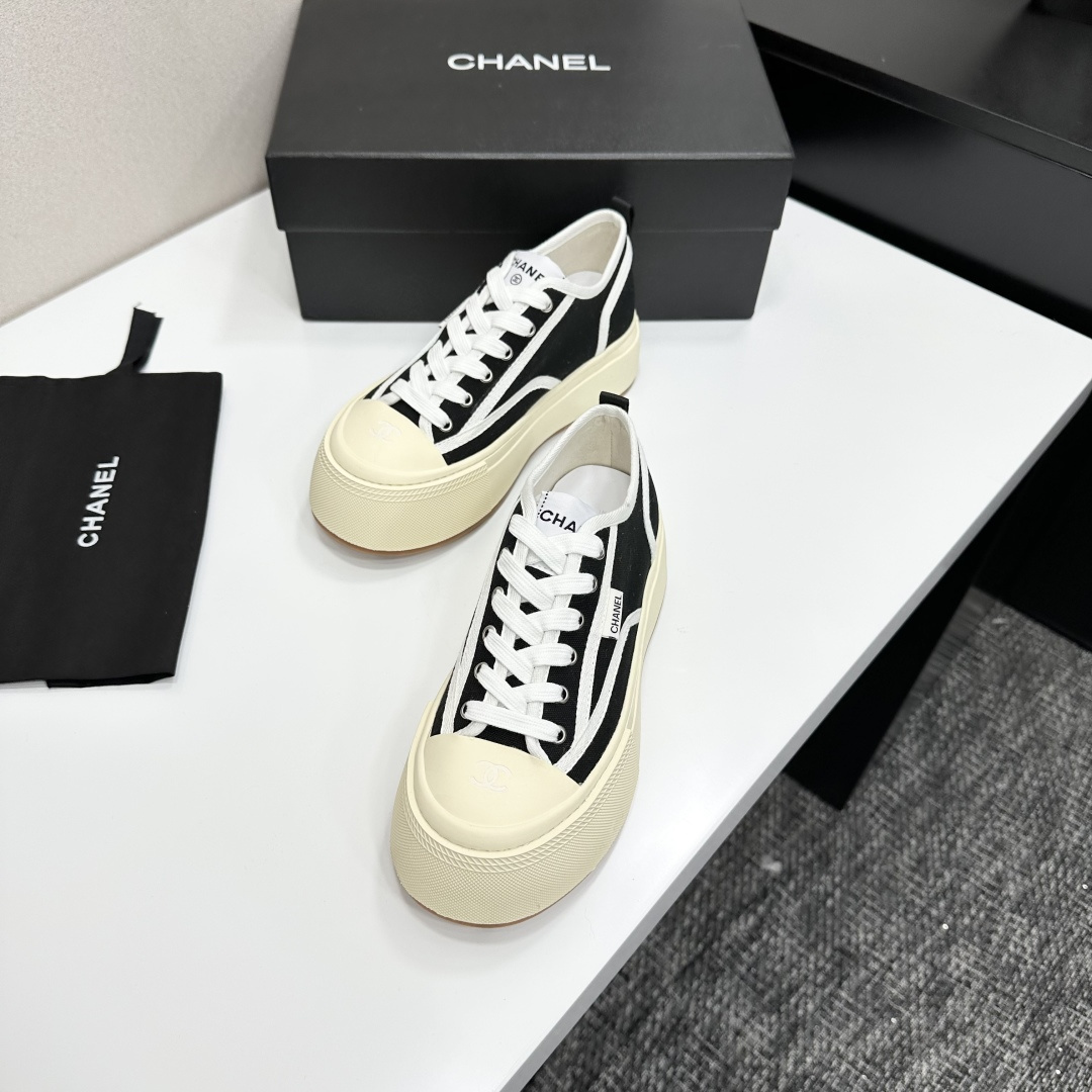 Chanel black canvas platform sneakers with white trim and thick cream soles on a black luxury box - Hình 6