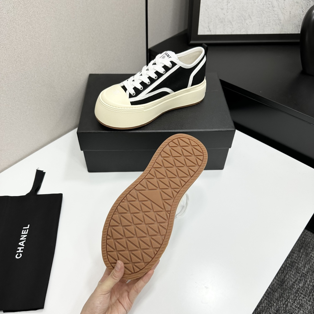 Chanel black canvas platform sneakers with white trim and thick cream soles on a black luxury box - Hình 5