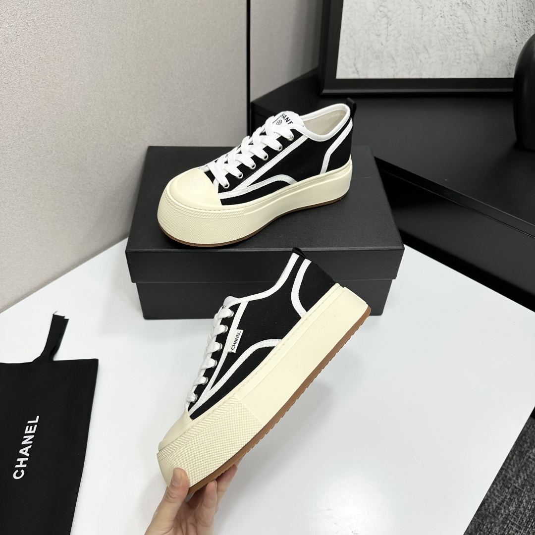Chanel black canvas platform sneakers with white trim and thick cream soles on a black luxury box - Hình 4