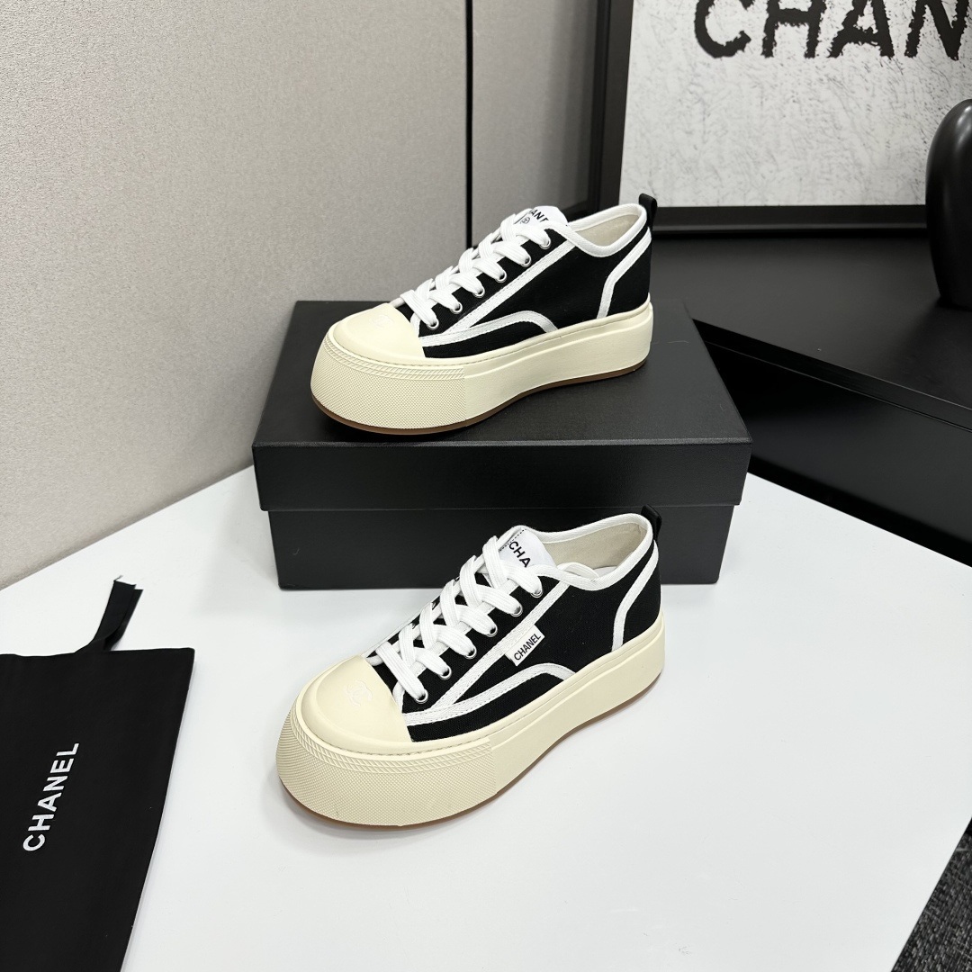Chanel black canvas platform sneakers with white trim and thick cream soles on a black luxury box - Hình 3