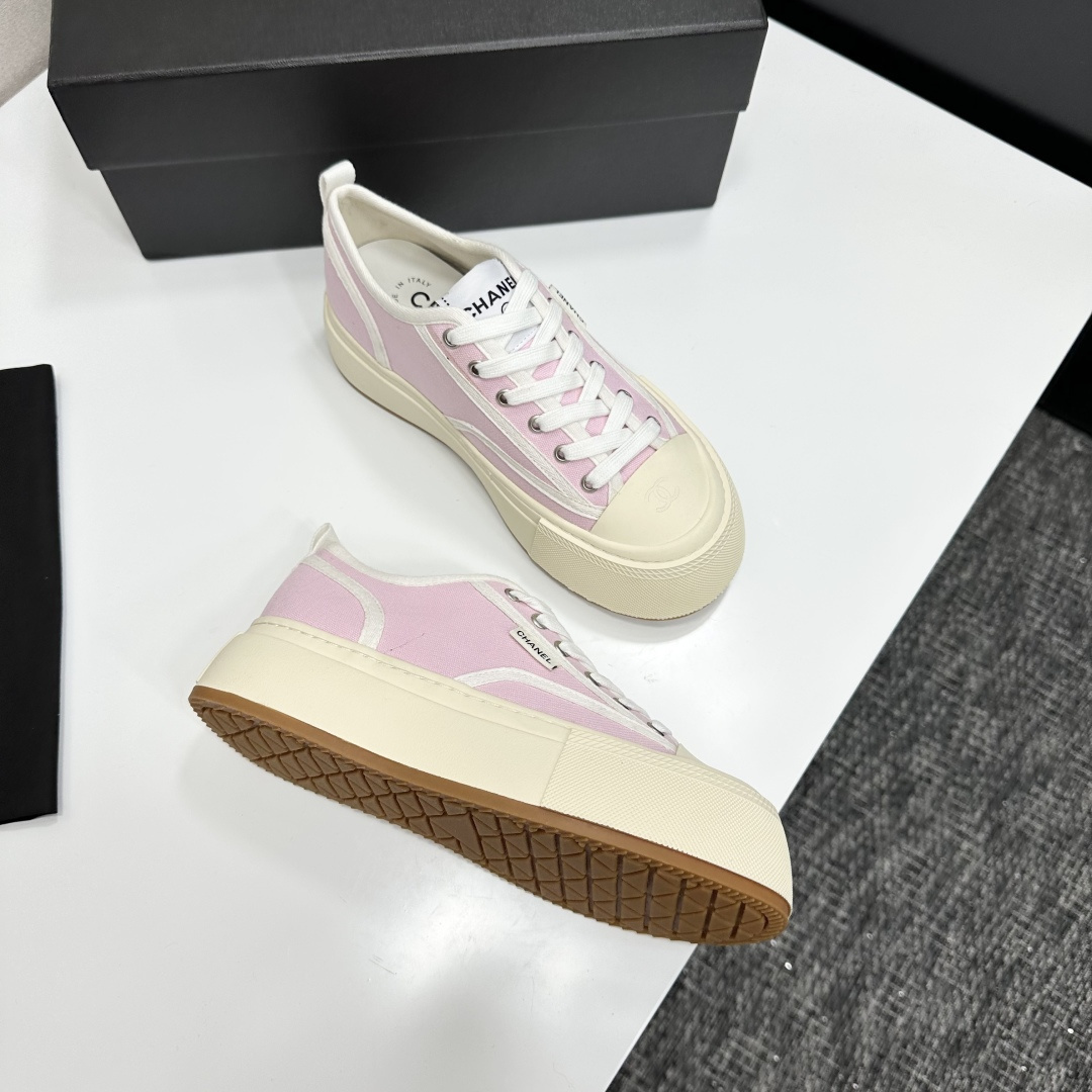 Chanel pink canvas sneakers with thick cream platform soles and white laces displayed on a black box. - Hình 8