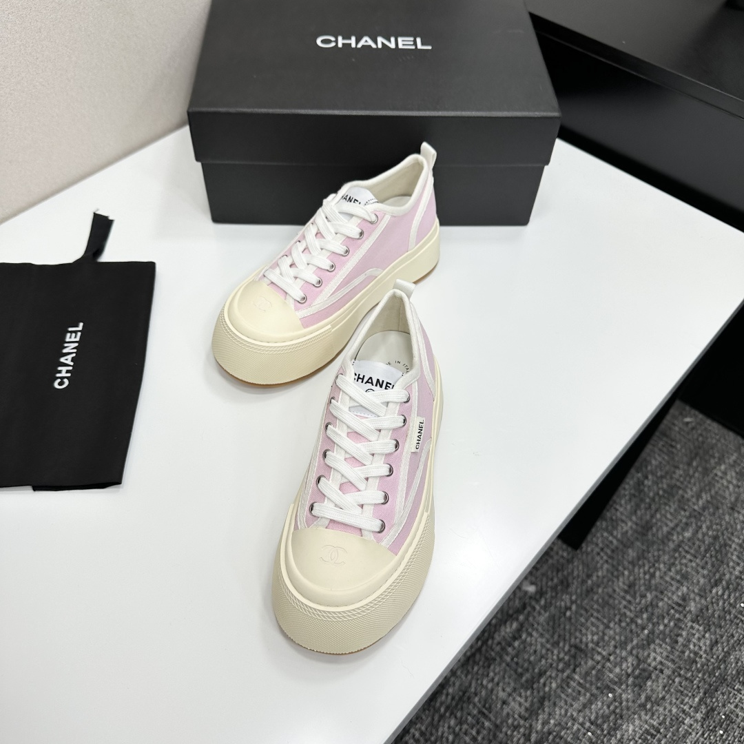 Chanel pink canvas sneakers with thick cream platform soles and white laces displayed on a black box. - Hình 5