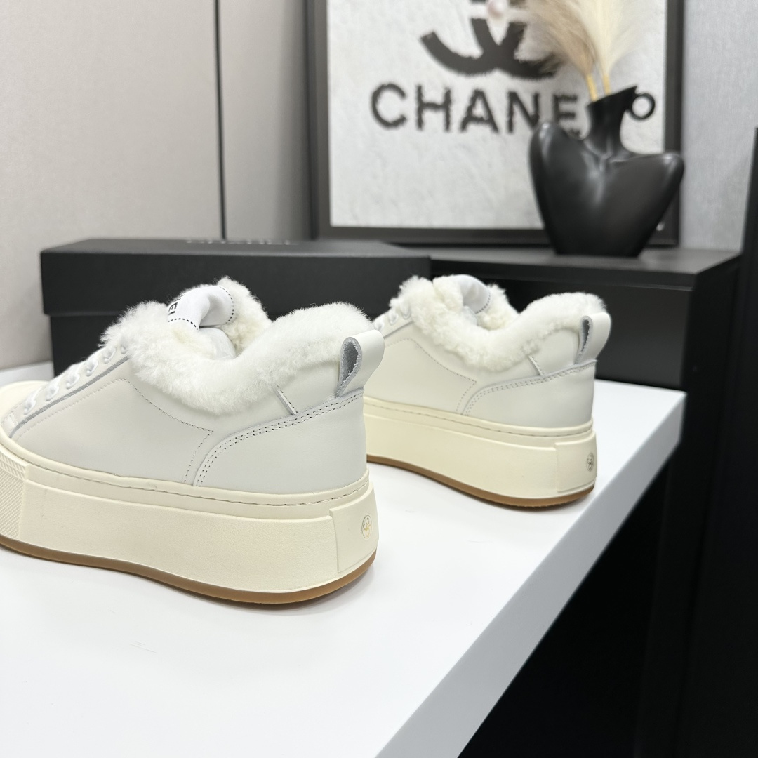 Pair of Chanel white leather platform sneakers with white shearling lining displayed on a black box - Hình 6