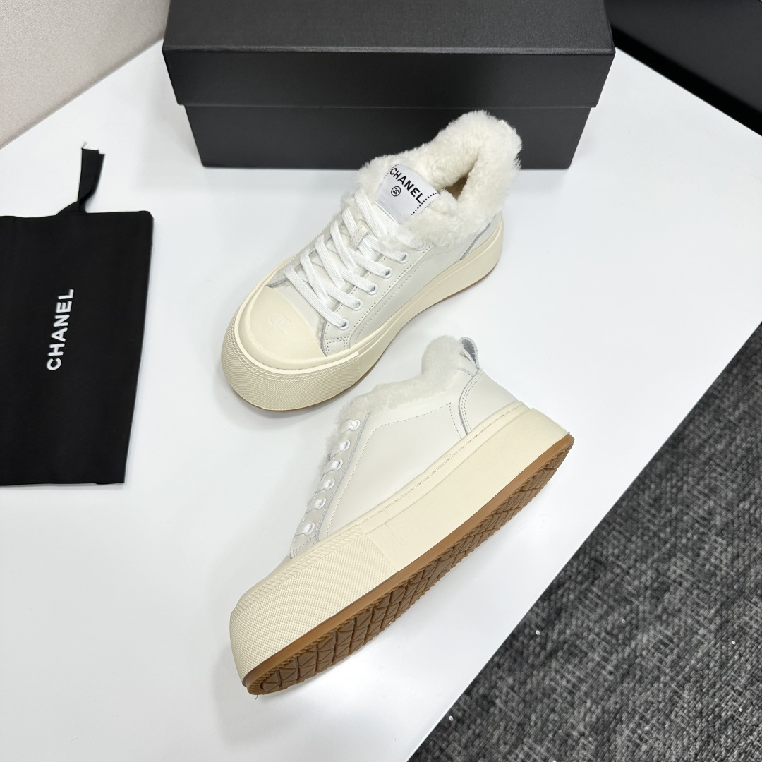 Pair of Chanel white leather platform sneakers with white shearling lining displayed on a black box - Hình 5
