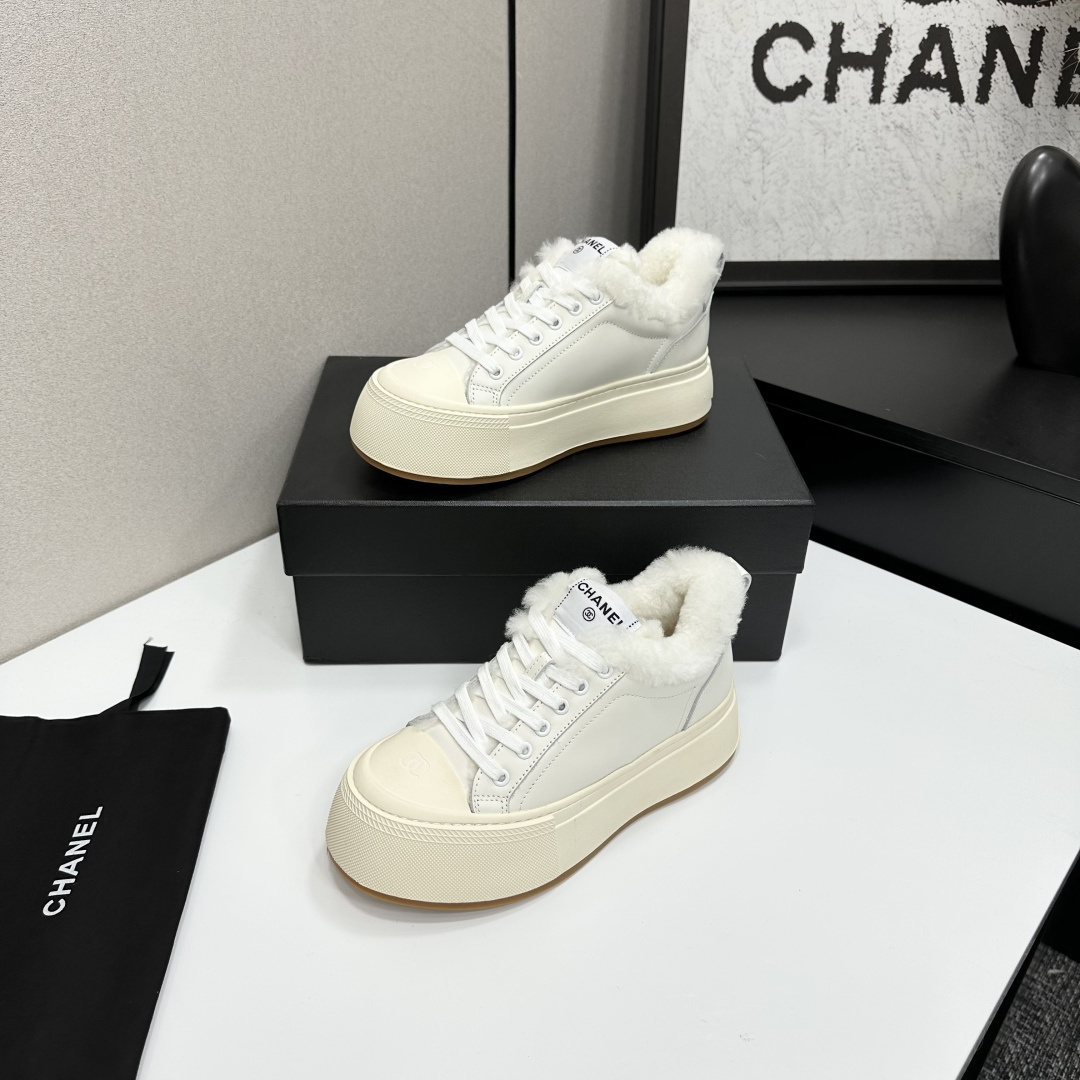 Pair of Chanel white leather platform sneakers with white shearling lining displayed on a black box - Hình 2