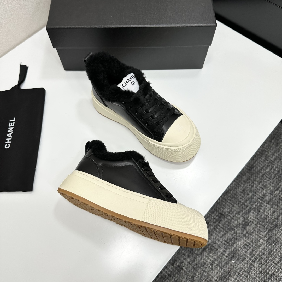 Luxury black leather Chanel sneakers with white platform soles and black fur lining displayed on a black box - Hình 7
