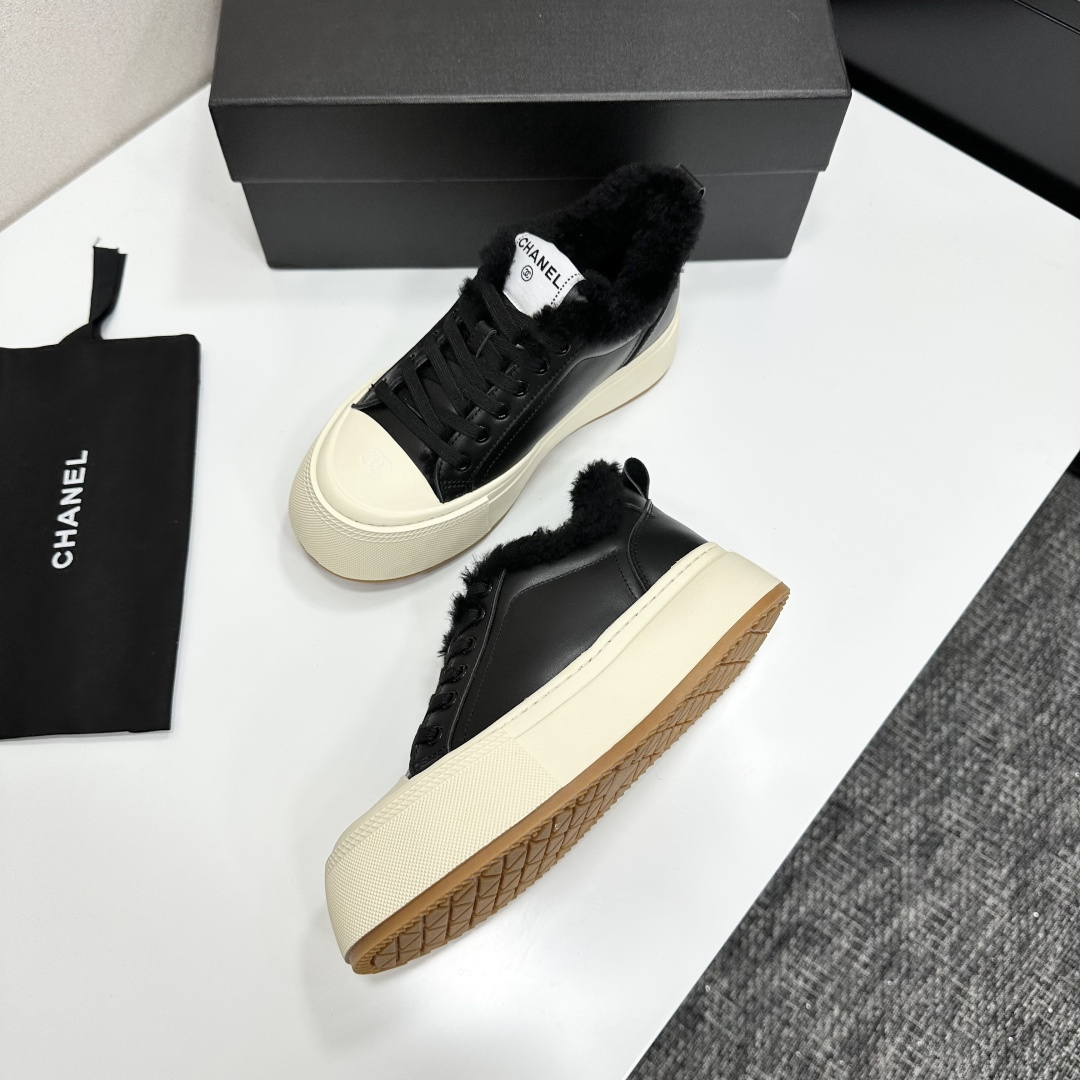 Luxury black leather Chanel sneakers with white platform soles and black fur lining displayed on a black box - Hình 5
