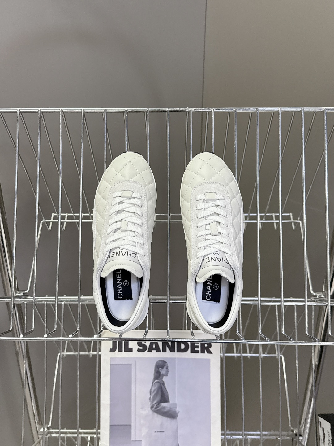 A pair of luxury white Chanel quilted leather sneakers with suede accents next to an original Chanel box. - Hình 6