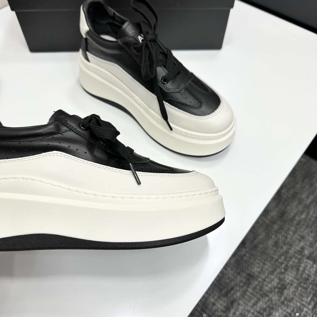 Pair of luxury Chanel black and white leather platform sneakers with a thick white chunky sole displayed on a black box. - Hình 8