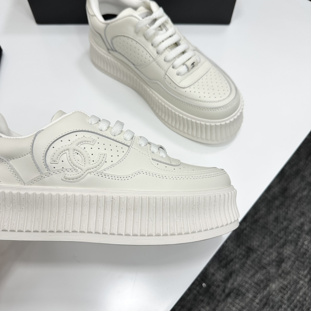Pair of white Chanel leather platform sneakers with interlocking CC logo on the side, displayed on a black luxury box. - Hình 9