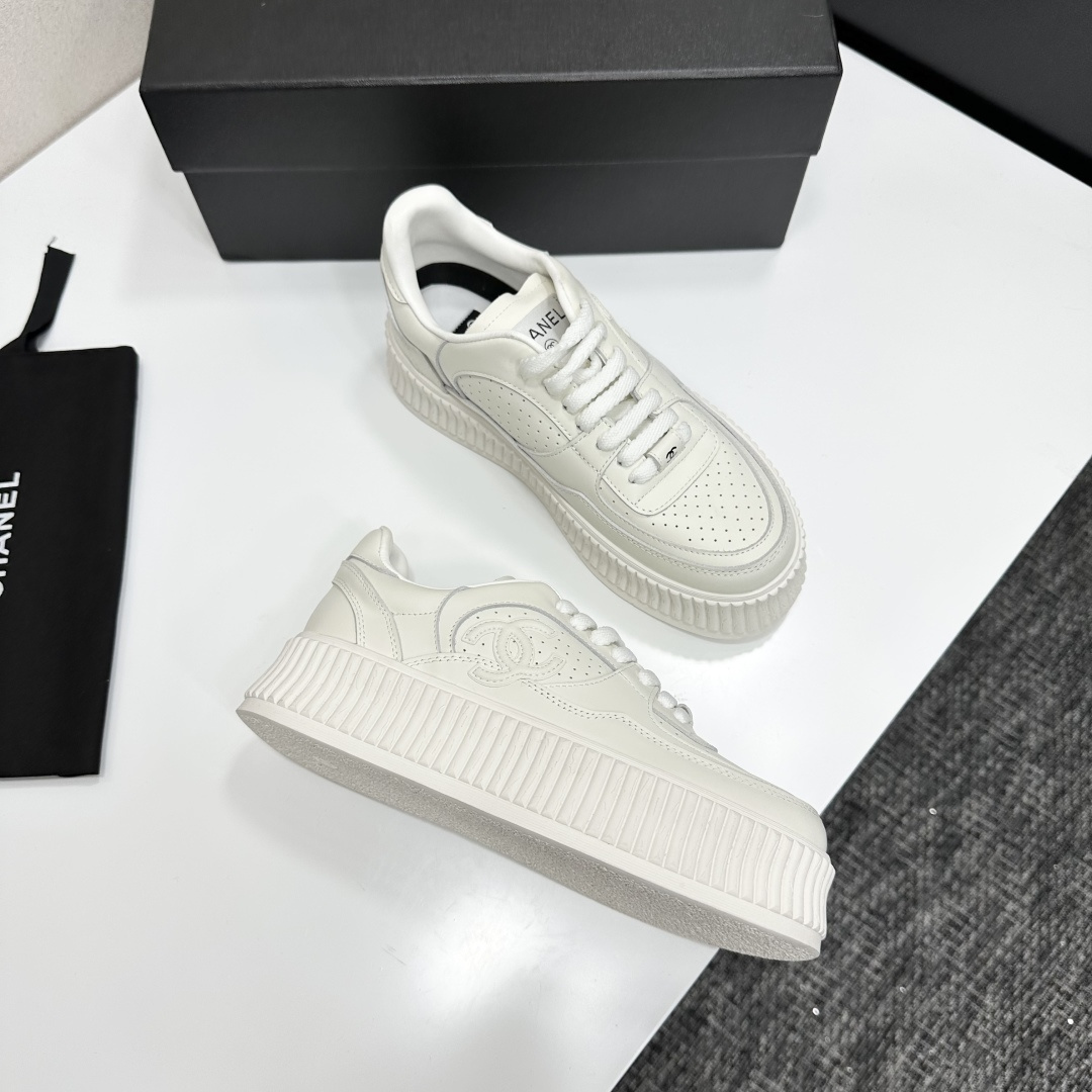 Pair of white Chanel leather platform sneakers with interlocking CC logo on the side, displayed on a black luxury box. - Hình 8