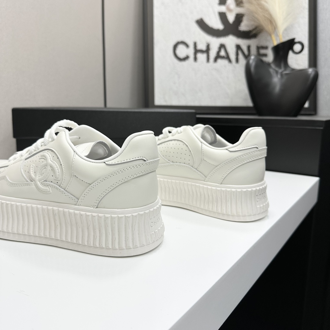 Pair of white Chanel leather platform sneakers with interlocking CC logo on the side, displayed on a black luxury box. - Hình 7