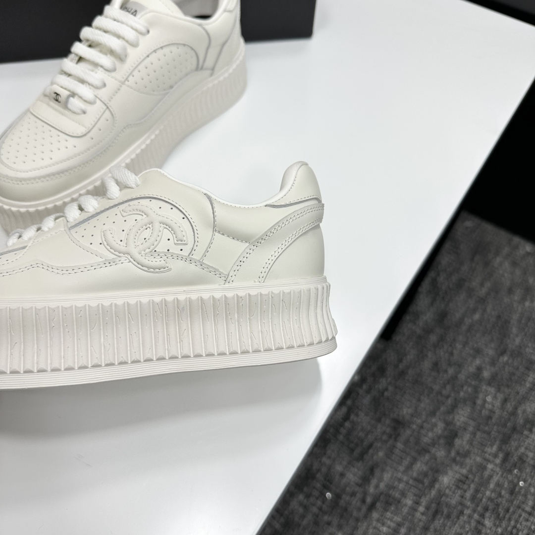 Pair of white Chanel leather platform sneakers with interlocking CC logo on the side, displayed on a black luxury box. - Hình 6