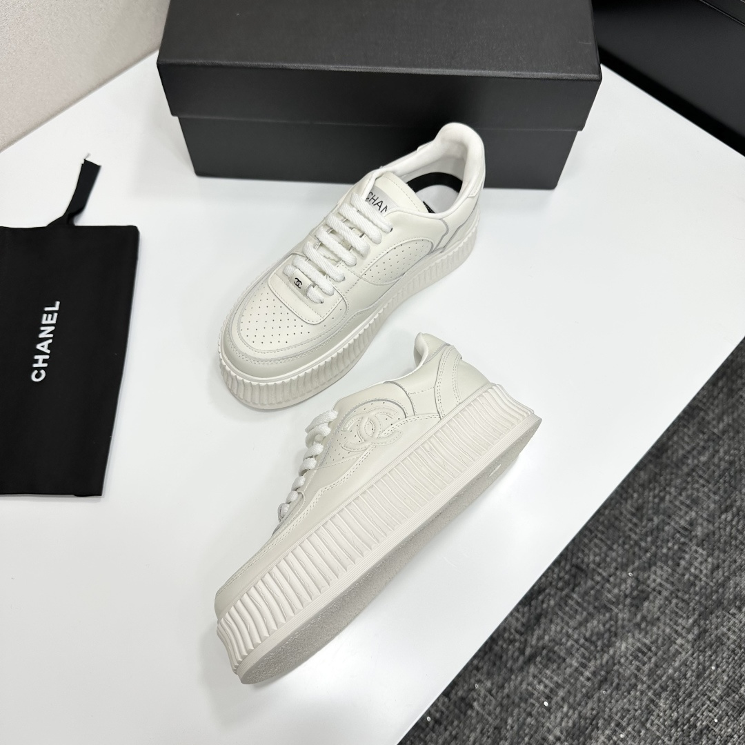 Pair of white Chanel leather platform sneakers with interlocking CC logo on the side, displayed on a black luxury box. - Hình 5
